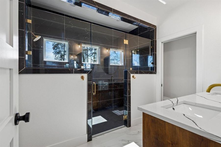 Bathroom with vanity and a shower with door