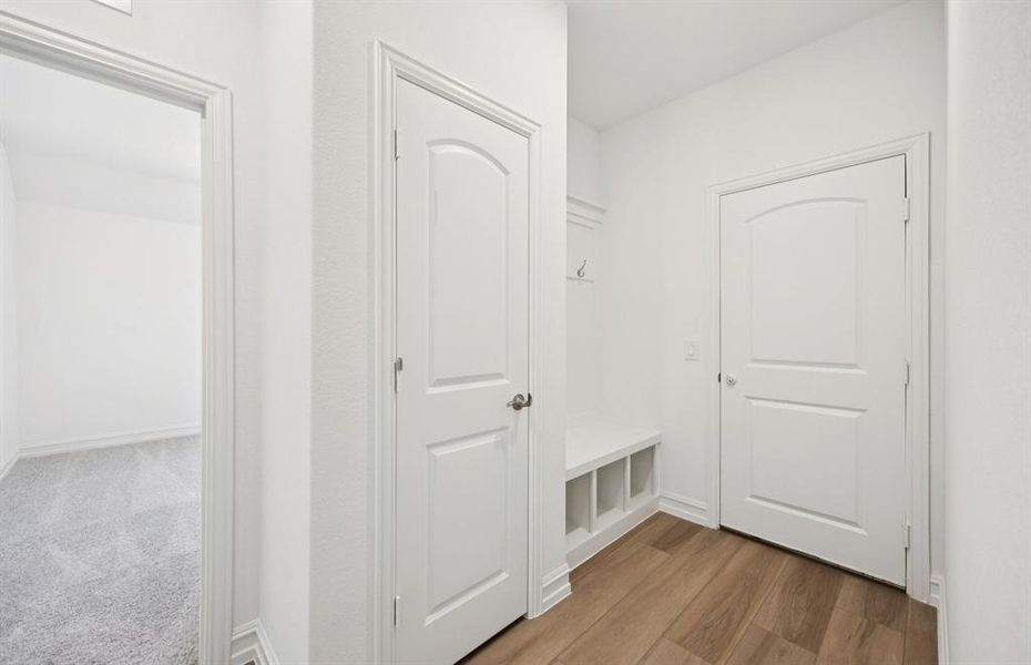 Mud room with built-in bench and hooks for added storage Mud room with built-in bench and hooks for added storage