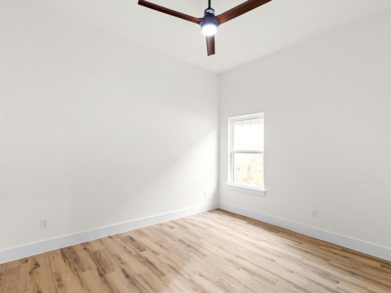 Empty room featuring light wood-type flooring and ceiling fan