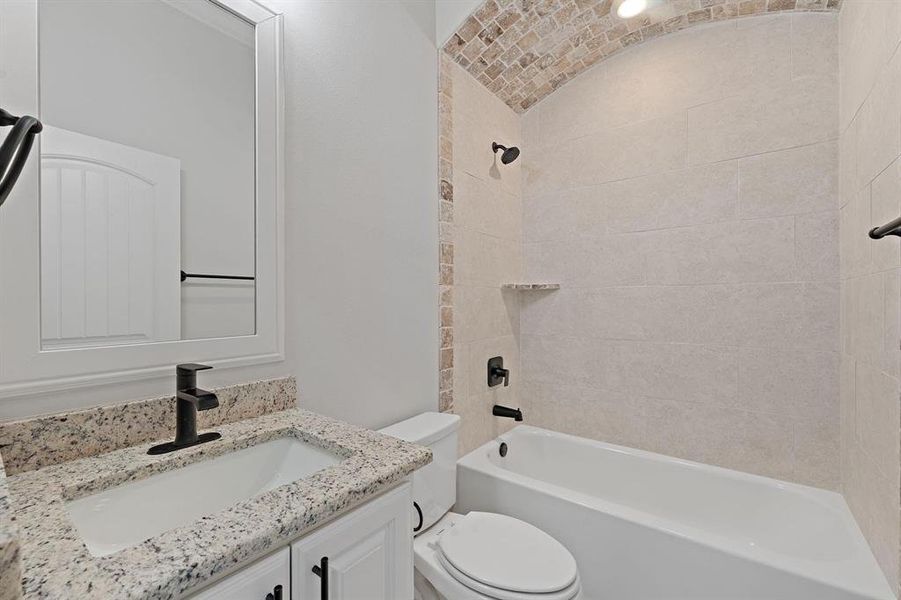 Full bath with vanity,  shower combination, and lofted ceiling