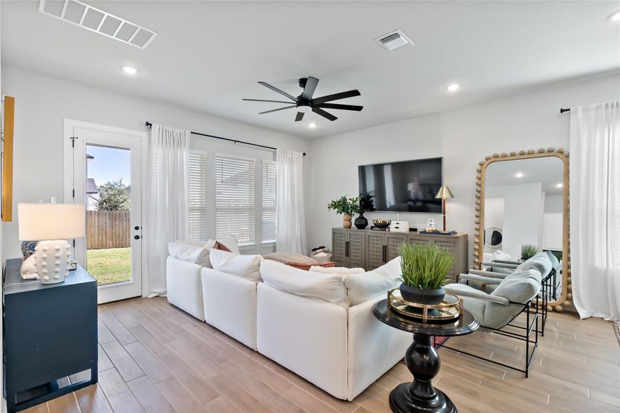 Living area featuring wood tiled floors, ceiling fan, and recessed lighting