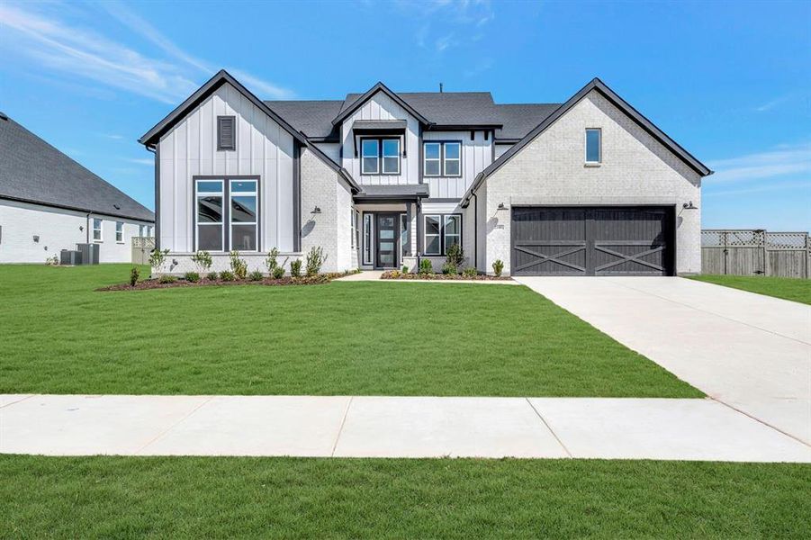 Modern farmhouse style home featuring board and batten siding and driveway Modern farmhouse style home featuring board and batten siding and driveway