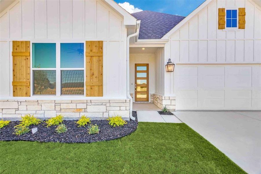 View of front of property with a front yard and a garage