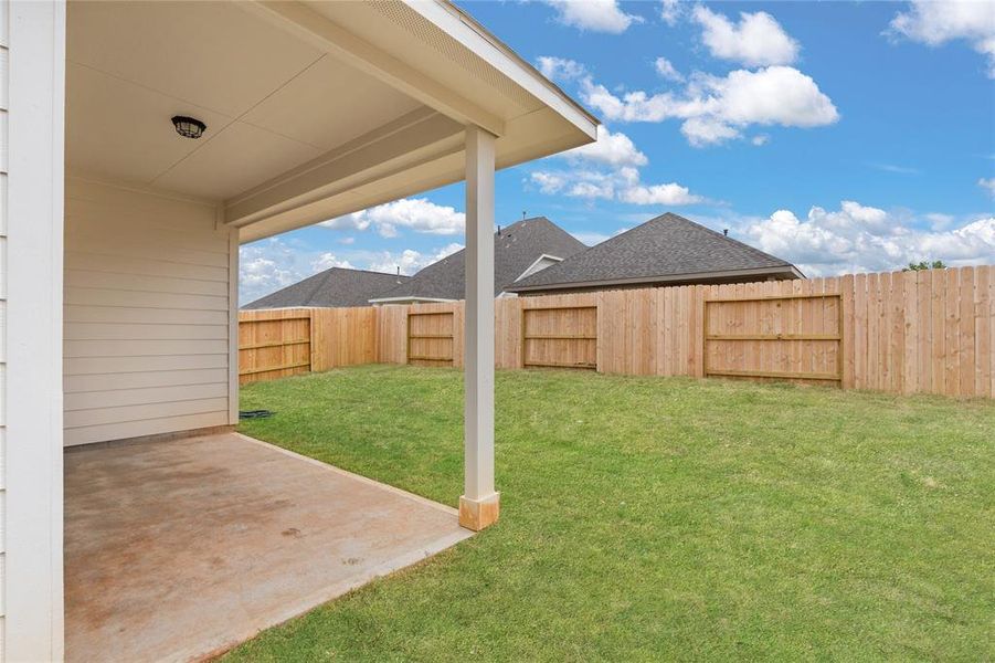 The covered patio is generously sized, providing ample space for various outdoor activities.