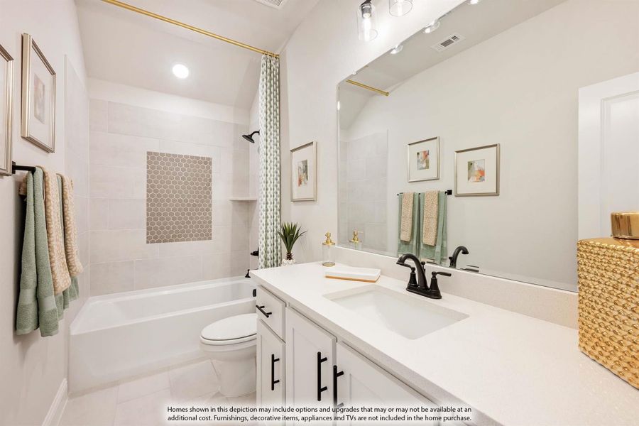 Bathroom with white vanity, tiled shower-tub combo, and large mirror with gold trim accents