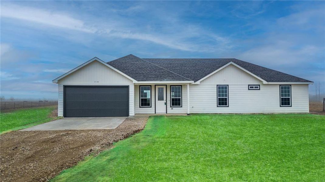 Single story home featuring a garage and a front yard