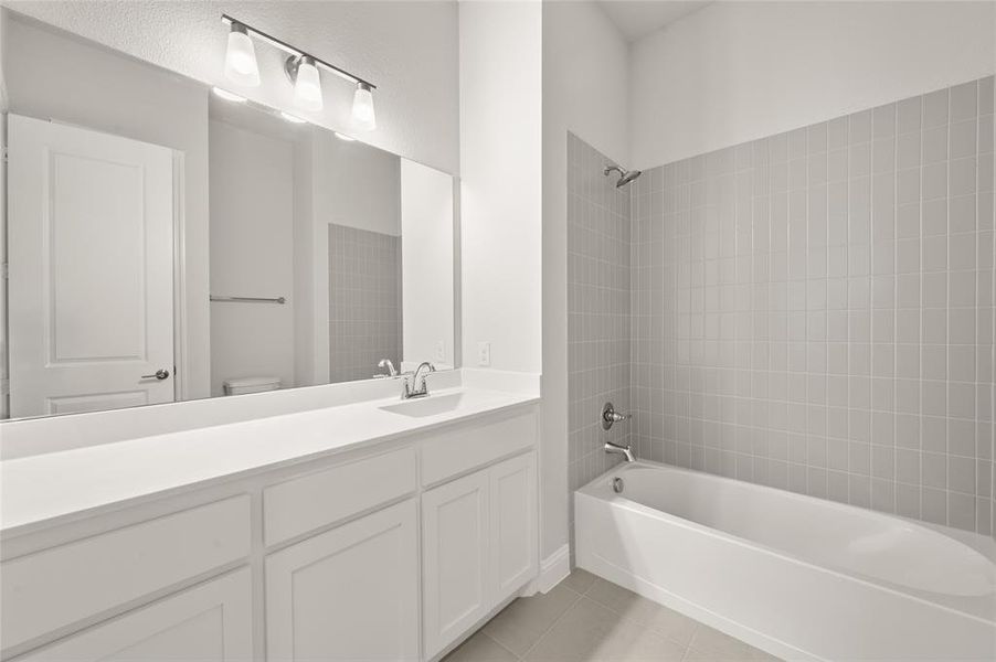 Full bathroom with shower / washtub combination, light tile patterned flooring, and vanity