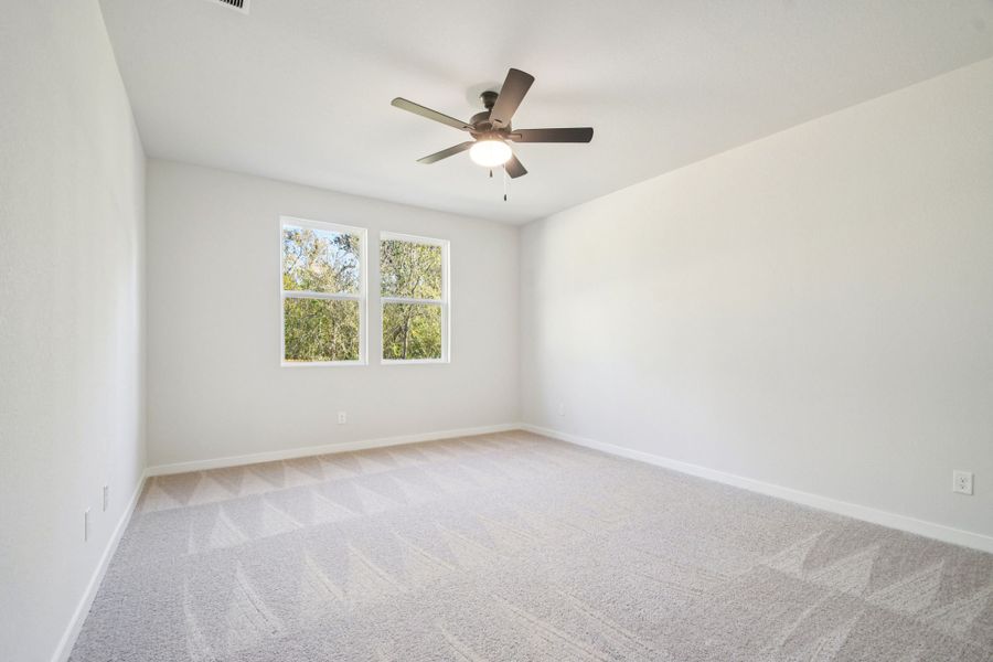A room with a ceiling fan and a window.