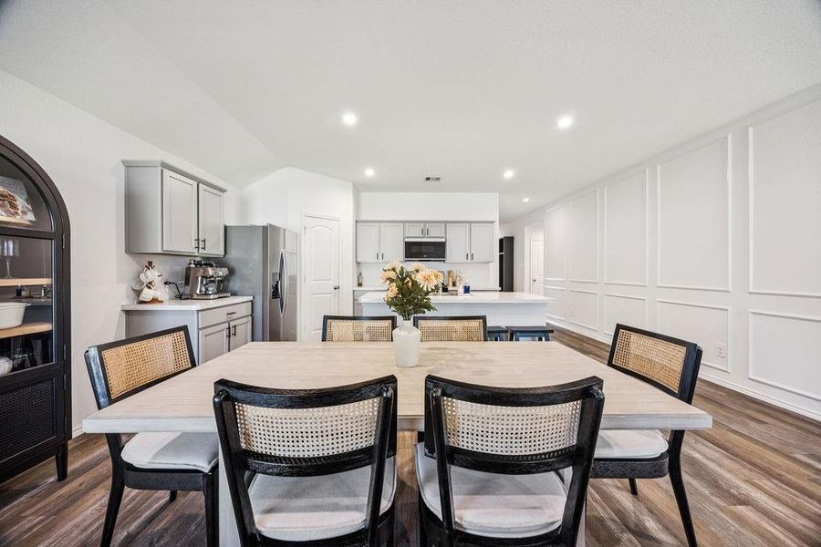 Experience modern elegance in this open-concept kitchen and dining area, featuring sleek cabinetry and a spacious layout perfect for entertaining. Experience modern elegance in this open-concept kitchen and dining area, featuring sleek cabinetry and a spacious layout perfect for entertaining.
