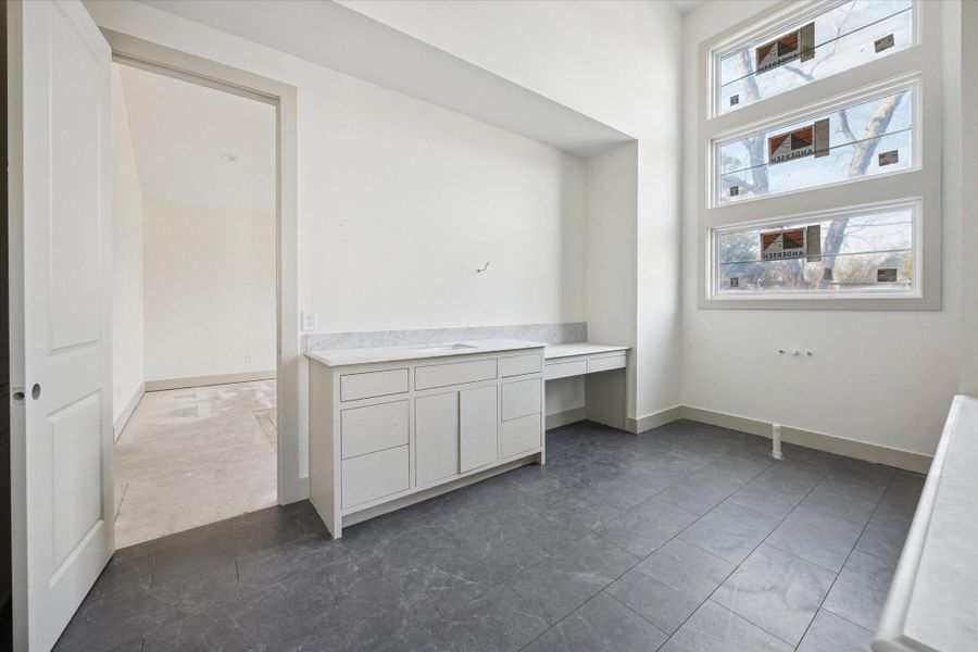 PRIMARY BATHROOM - An extended vanity adds flexibility to the primary bath, creating space for daily routines beyond the sink. Tall windows bring in soft natural light, while durable tile flooring and clean finishes maintain a calm, functional feel. -- Construction as of 1/5/26