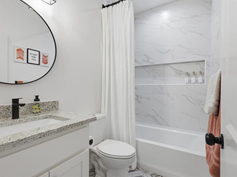 Full bathroom has built in cabinet and vanity.