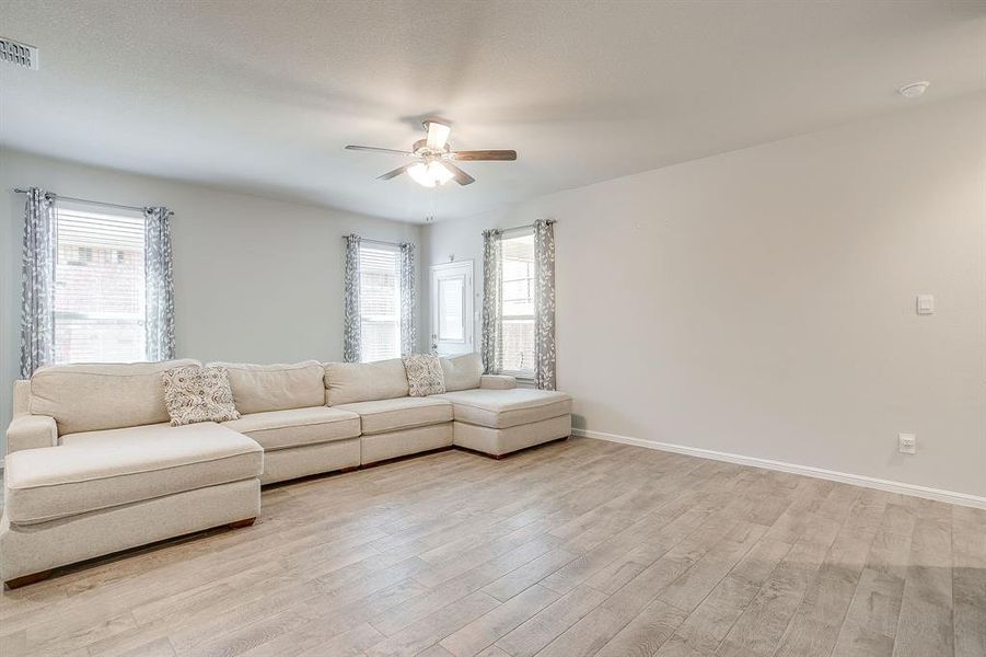 Living area with light wood-type flooring and ceiling fan