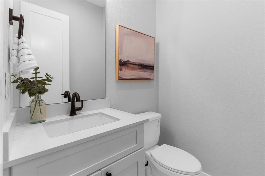 The powder room continues the home's narrative with its polished black hardware, an aesthetic echo of consistency.