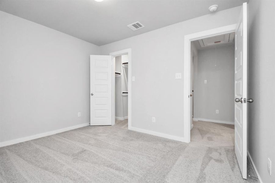 Secondary bedroom features plush carpeting, large windows that let in plenty of natural light, bright paint, and spacious closets. Sample photo of completed home with similar floor plan. Actual colors and selections may vary.