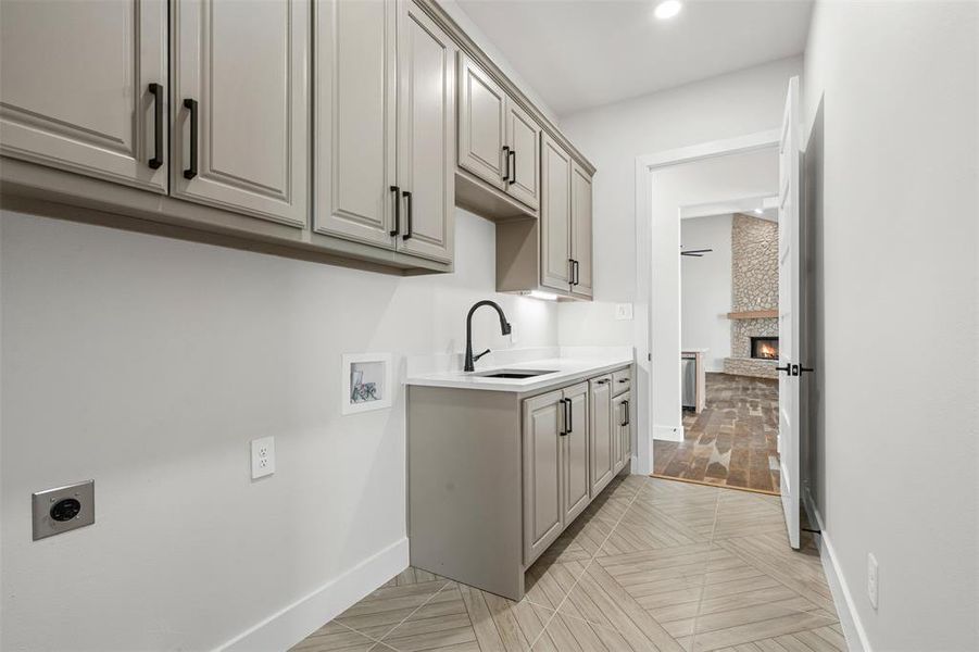Laundry area featuring a fireplace, cabinet space, hookup for a washing machine, hookup for an electric dryer, and recessed lighting