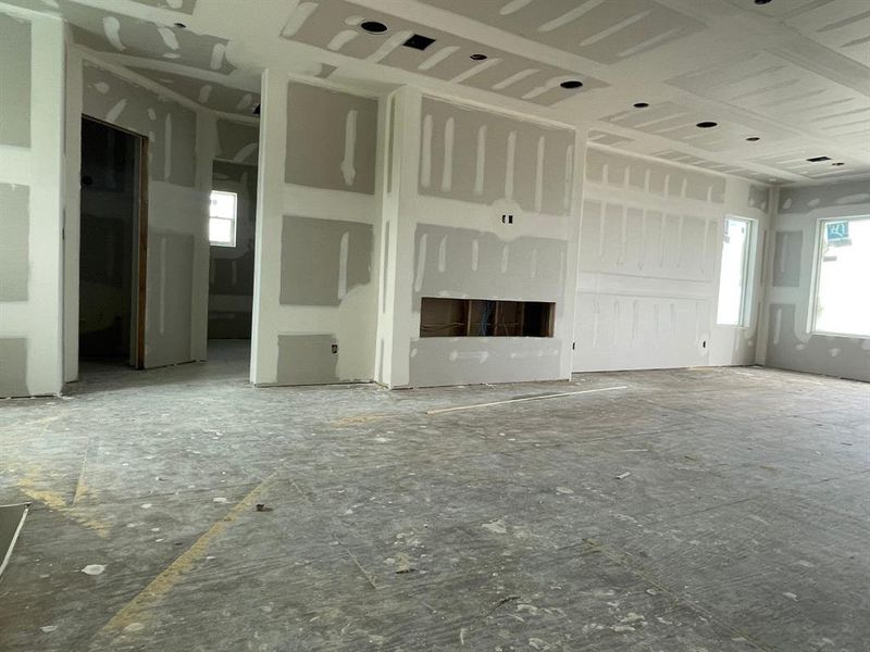 This spacious upstairs game room features an electric fireplace and will include a built-in entertainment area. The hallway to the left leads to two of the home's four primary suites—ideal for hosting multiple families or maximizing short-term rental revenue. This spacious upstairs game room features an electric fireplace and will include a built-in entertainment area. The hallway to the left leads to two of the home's four primary suites—ideal for hosting multiple families or maximizing short-term rental revenue.