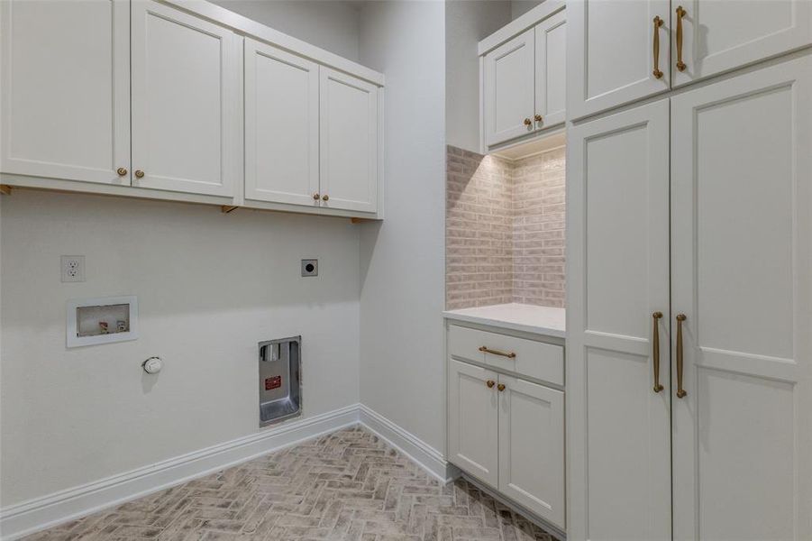 Laundry area featuring cabinet space, hookup for an electric dryer, gas dryer hookup, washer hookup, and baseboards