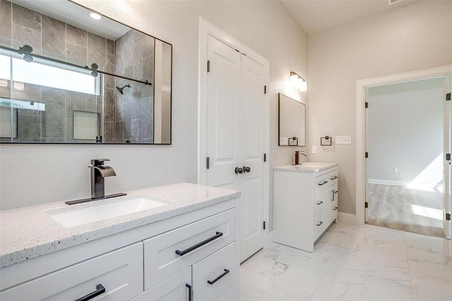 Bathroom featuring a sink, two vanities, a shower stall, and marble finish floor Bathroom featuring a sink, two vanities, a shower stall, and marble finish floor