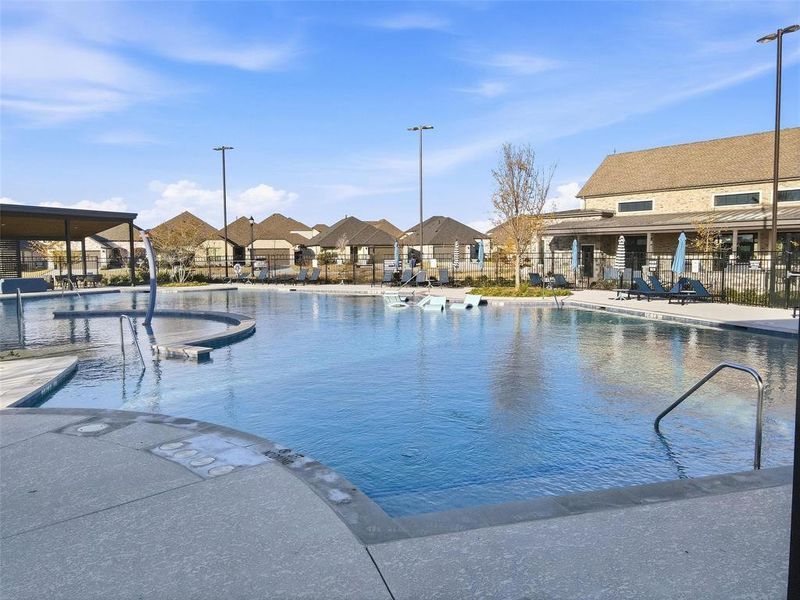 Community pool with a patio area and a residential view