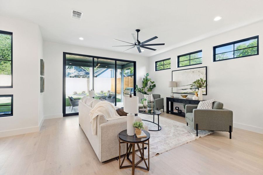 Living room with light wood-style floors, plenty of natural light, recessed lighting, and ceiling fan