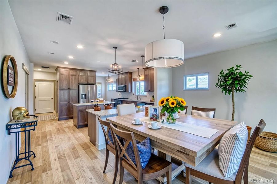 Virtually staged dining room and a look into the kitchen.