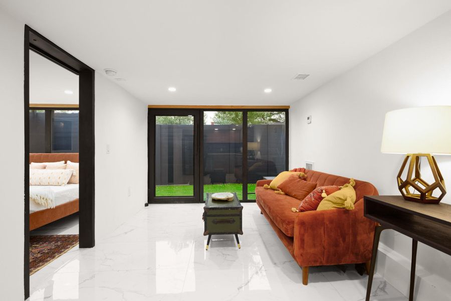 Living room with marble tiled floors, expansive windows, and recessed lighting