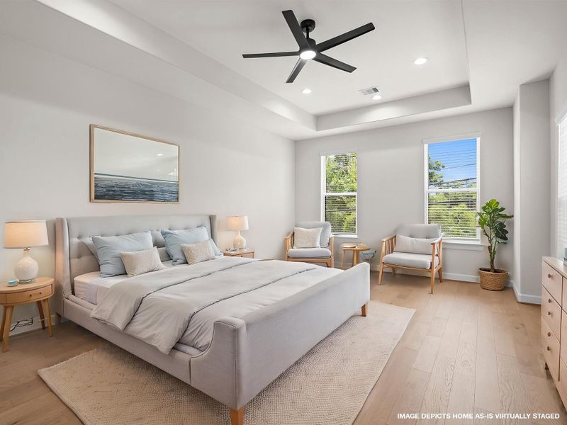 The expansive primary bedroom delivers a serene setting for rest and relaxation, thoughtfully positioned to provide privacy and everyday comfort. Image depicts home as-is virtually staged.