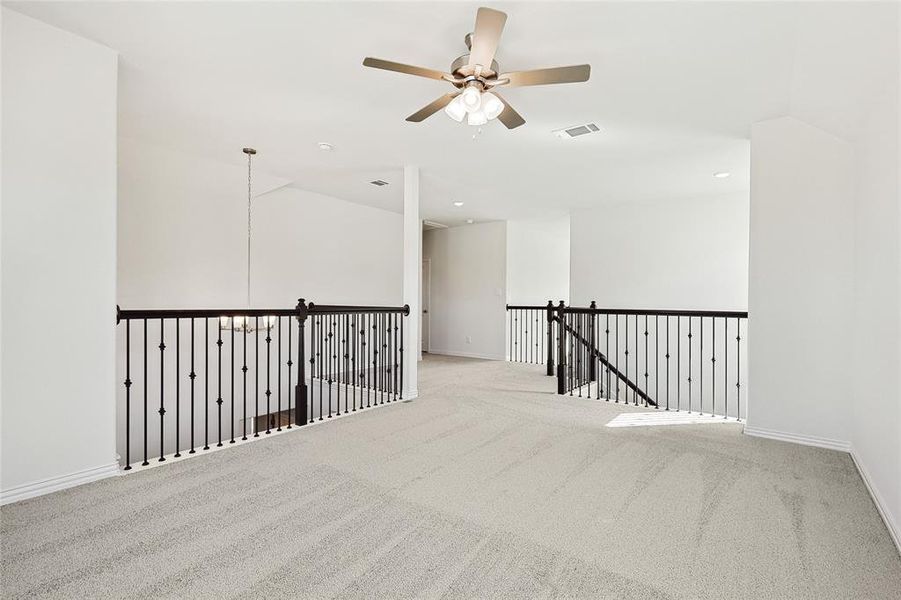 Carpeted empty room with ceiling fan and lofted ceiling