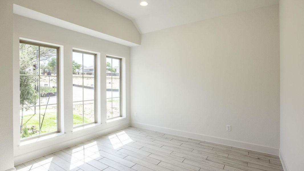 Unfurnished room with plenty of natural light, baseboards, lofted ceiling, light wood finished floors, and recessed lighting Unfurnished room with plenty of natural light, baseboards, lofted ceiling, light wood finished floors, and recessed lighting