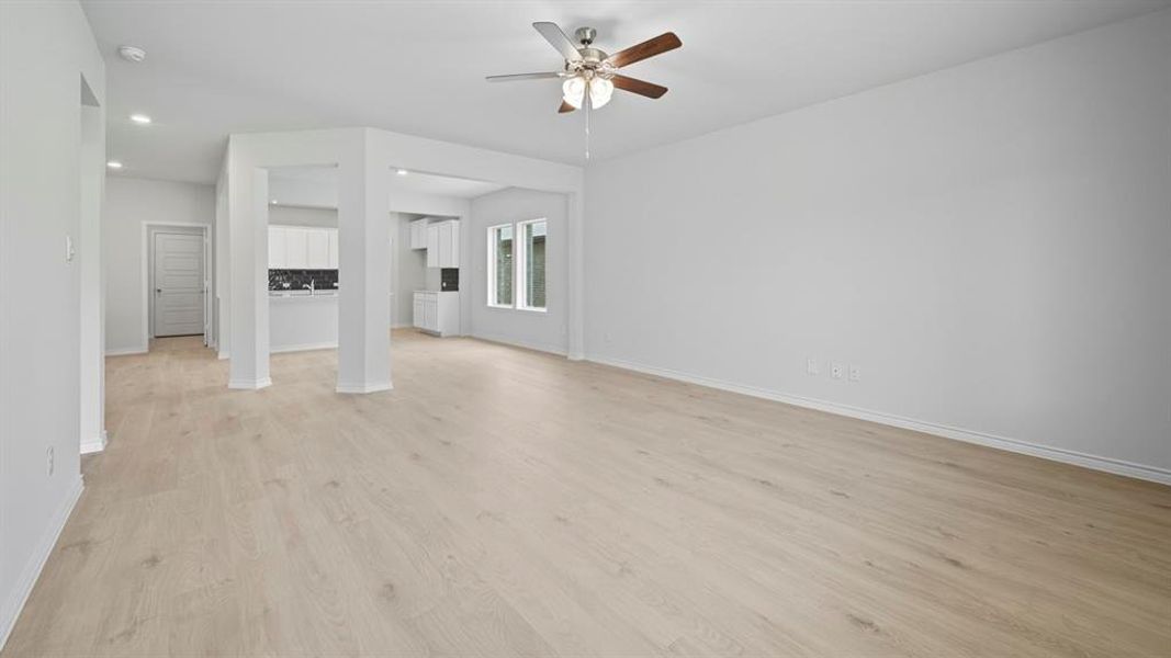 Unfurnished living room with light wood finished floors and ceiling fan Unfurnished living room with light wood finished floors and ceiling fan