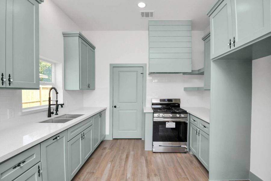 Find a trendy yet timeless kitchen with custom solid wood cabinetry and a stainless steel gas stove included. Not pictures is a stainless steel refrigerator that is also included!