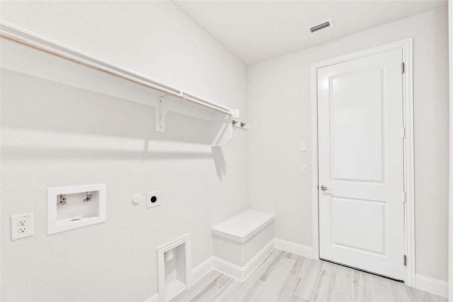 Laundry room with white walls, hanging rod, washer and dryer hookups, and light wood-look tile floors Laundry room with white walls, hanging rod, washer and dryer hookups, and light wood-look tile floors