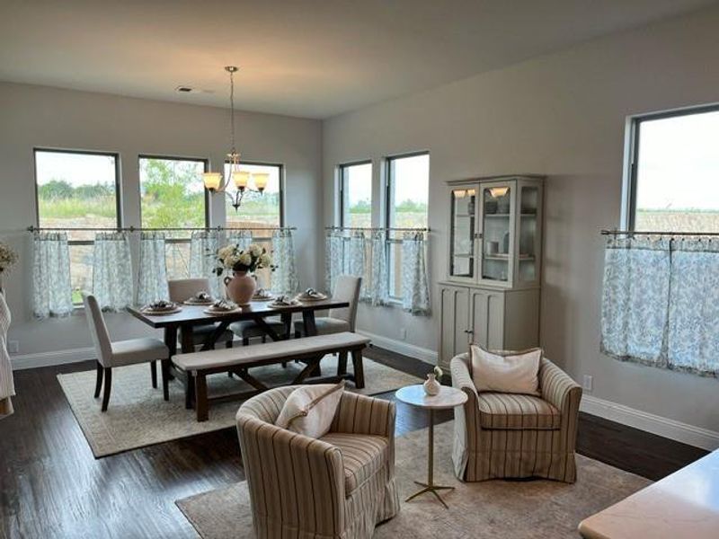 Dining area with a chandelier and dark wood-type flooring Dining area with a chandelier and dark wood-type flooring