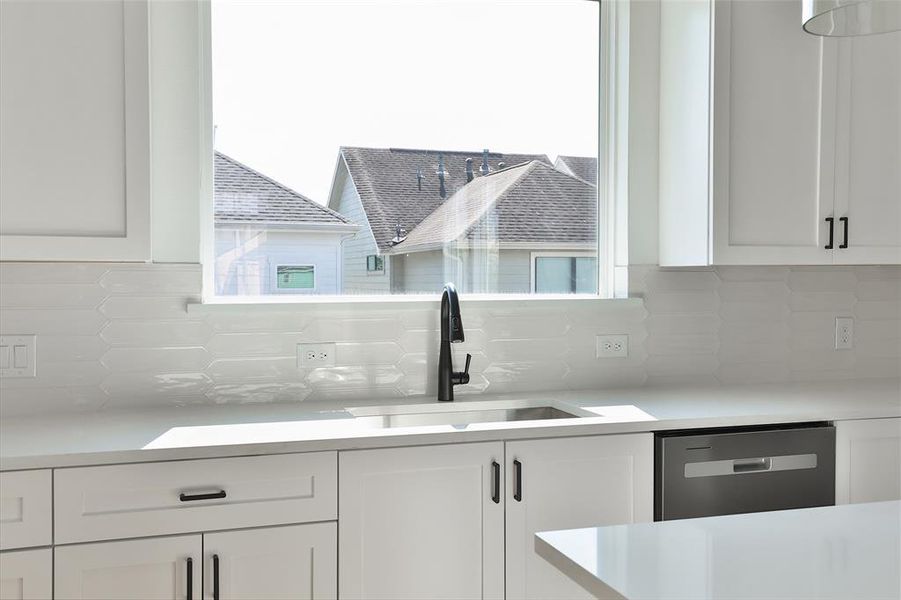 Take in the view through your picture window above your kitchen sink, complemented by 12"x3" glossy white subway picket tiles.