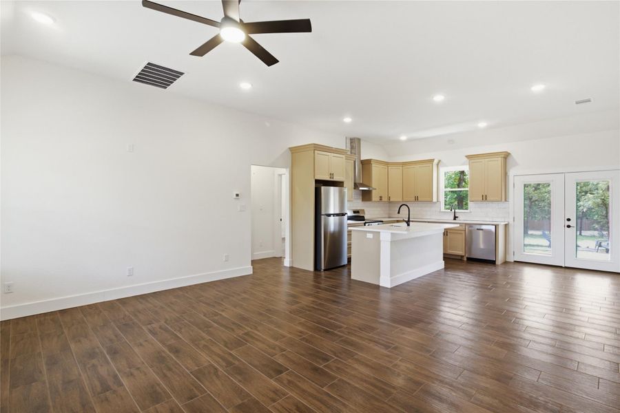 A contemporary kitchen and living area flows seamlessly, highlighted by rich wood-look flooring and abundant natural light. A contemporary kitchen and living area flows seamlessly, highlighted by rich wood-look flooring and abundant natural light.