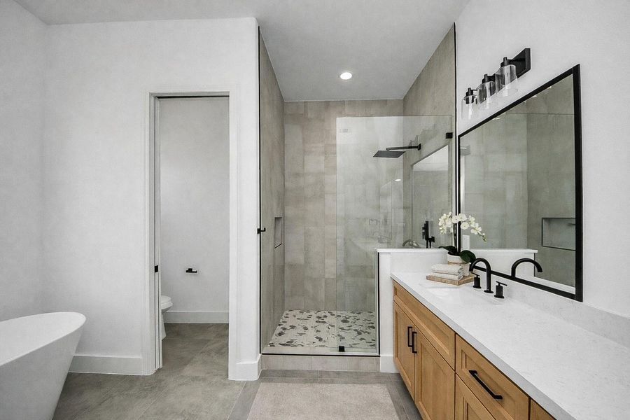 Spa-like primary bathroom retreat featuring a freestanding soaking tub, walk-in shower, and clean modern finishes.