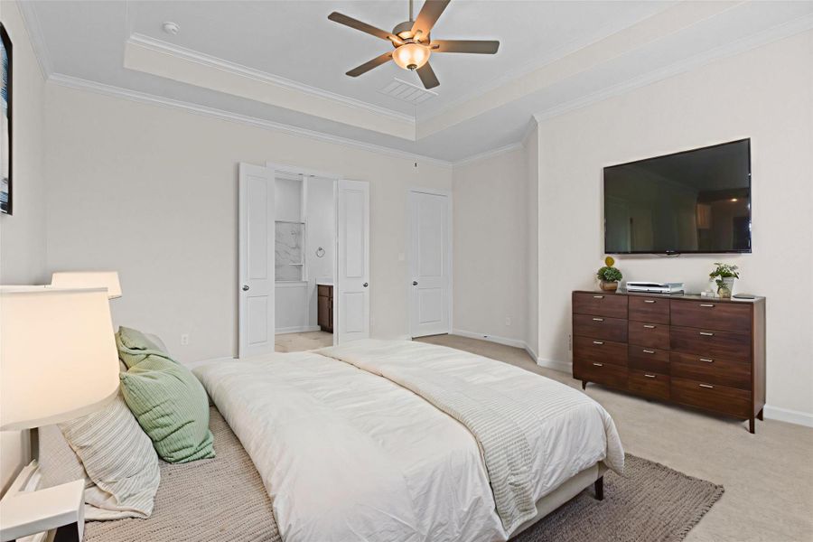 Another staged view of the primary suite highlighting space for a sitting area, media setup, or additional furnishings.