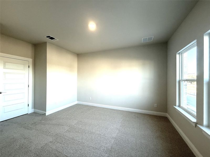 Carpeted spare room featuring baseboards