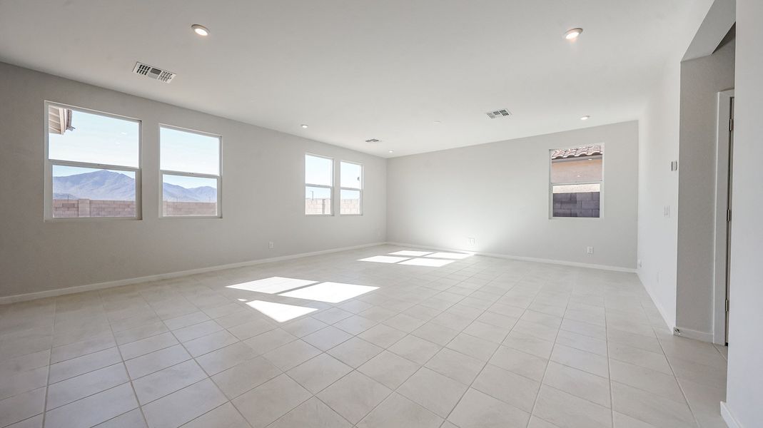A large empty room with a tile floor and large windows.