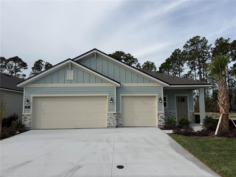Front exterior of a new home in The Magnolia Series at Reserve East, Flagler Beach, FL, highlighting curb appeal (Image 1). Front exterior of a new home in The Magnolia Series at Reserve East, Flagler Beach, FL, highlighting curb appeal (Image 1).