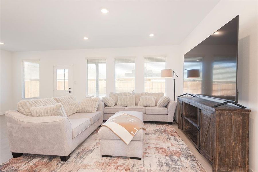 Living room featuring recessed lighting, wood finished floors, and plenty of natural light Living room featuring recessed lighting, wood finished floors, and plenty of natural light
