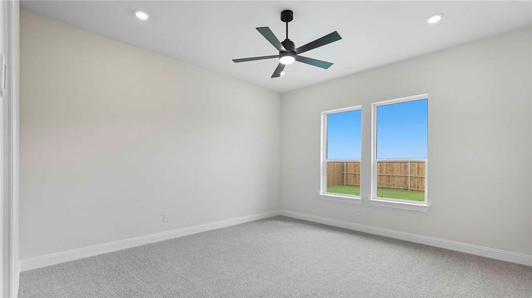 Carpeted room with a modern ceiling fan, recessed lighting, and two windows