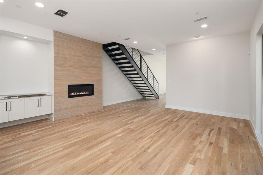 Unfurnished living room with a tile fireplace and light hardwood / wood-style floors