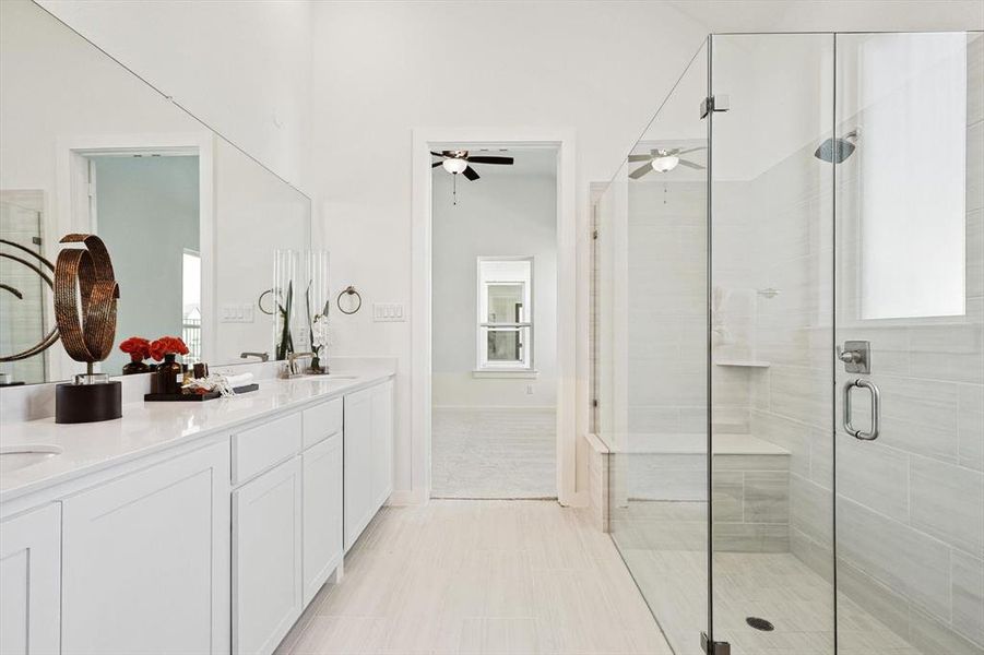 Bathroom with a wealth of natural light, vanity, ceiling fan, and a shower with shower door