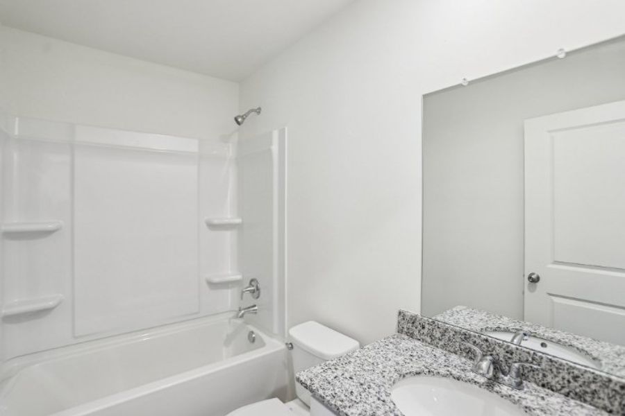 A bathroom with a tub sink and toilet.