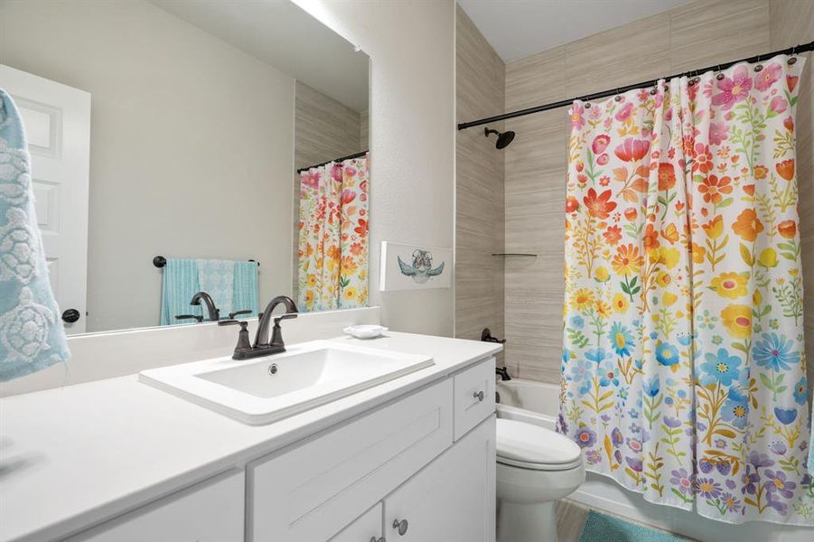 Bathroom featuring a white vanity with integrated sink, bronze-finish faucet, and coordinating hardware Bathroom featuring a white vanity with integrated sink, bronze-finish faucet, and coordinating hardware