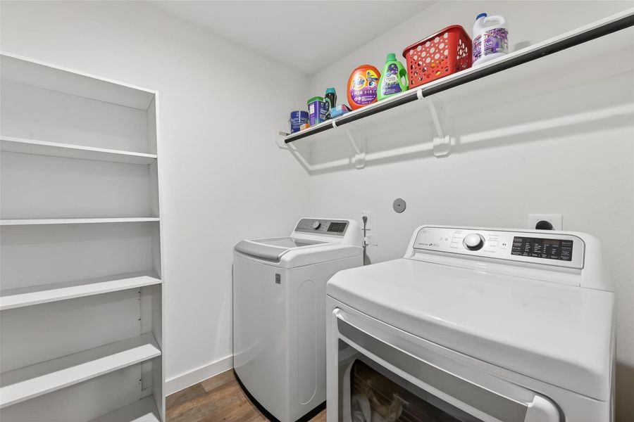Spacious laundry room featuring additional shelving for enhanced storage and easy organization