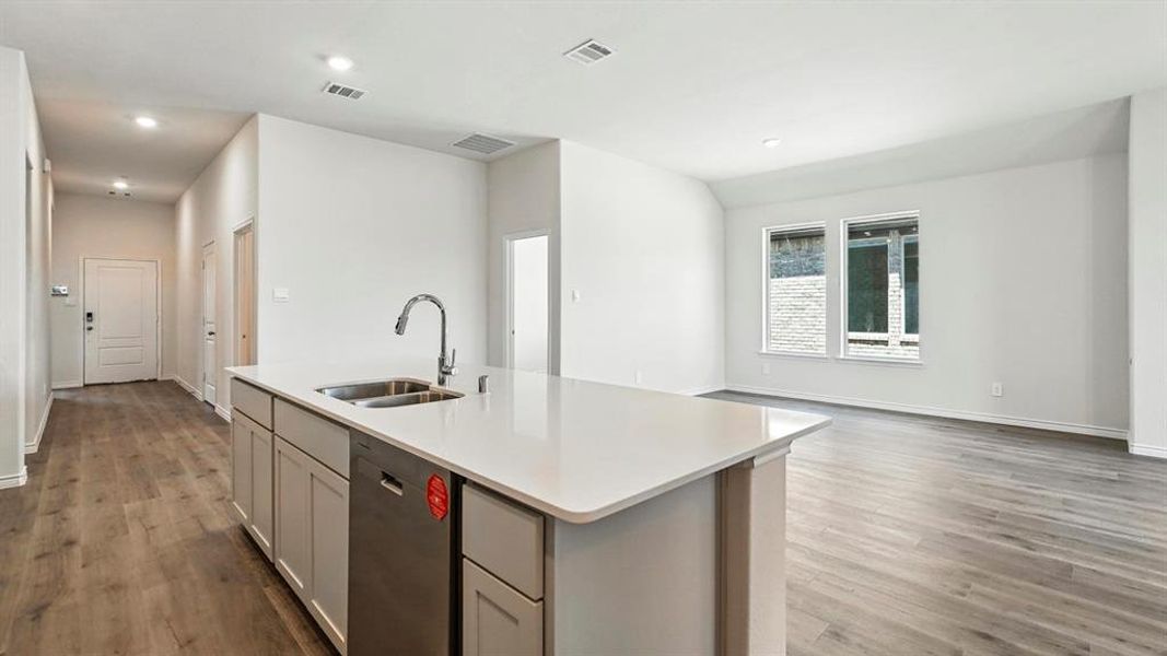 Kitchen with dishwasher, dark wood-type flooring, recessed lighting, an island with sink, and open floor plan