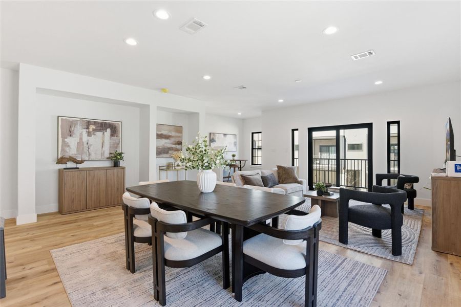 Spacious open living area with dining for six, sleek wood flooring, large windows, and elegant neutral décor that creates a warm, inviting atmosphere.