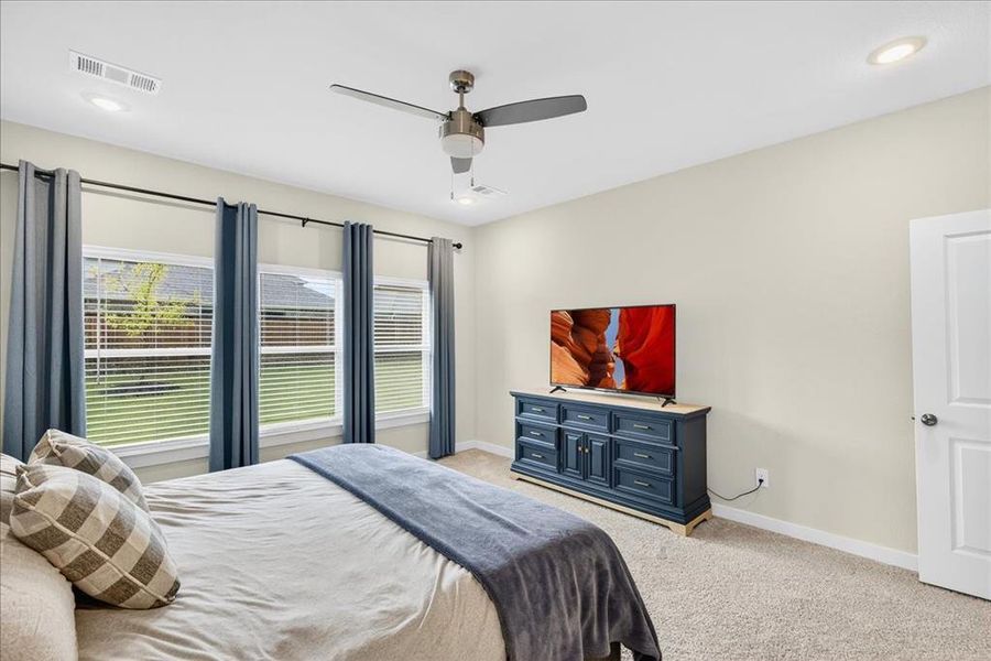 Bedroom featuring light colored carpet, a ceiling fan, and recessed lighting
